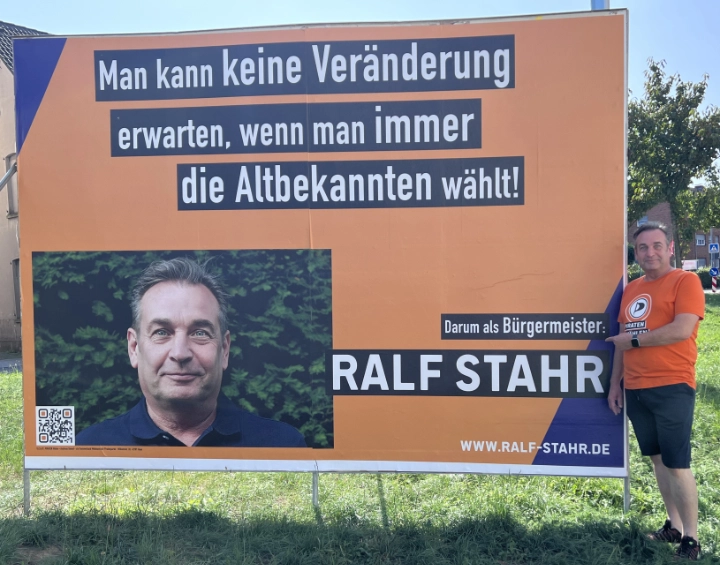 Ralf Stahr, Bürgermeisterkandidat der PIRATEN Hilden, rechts neben dem Wesselmann stehend, Standort Aldi-Ei, direkt hinter der Ausfahrt von Aldi in Richtung Innenstadt Hilden Wahlplakat mit Bürgermeisterkandidat Ralf Stahr